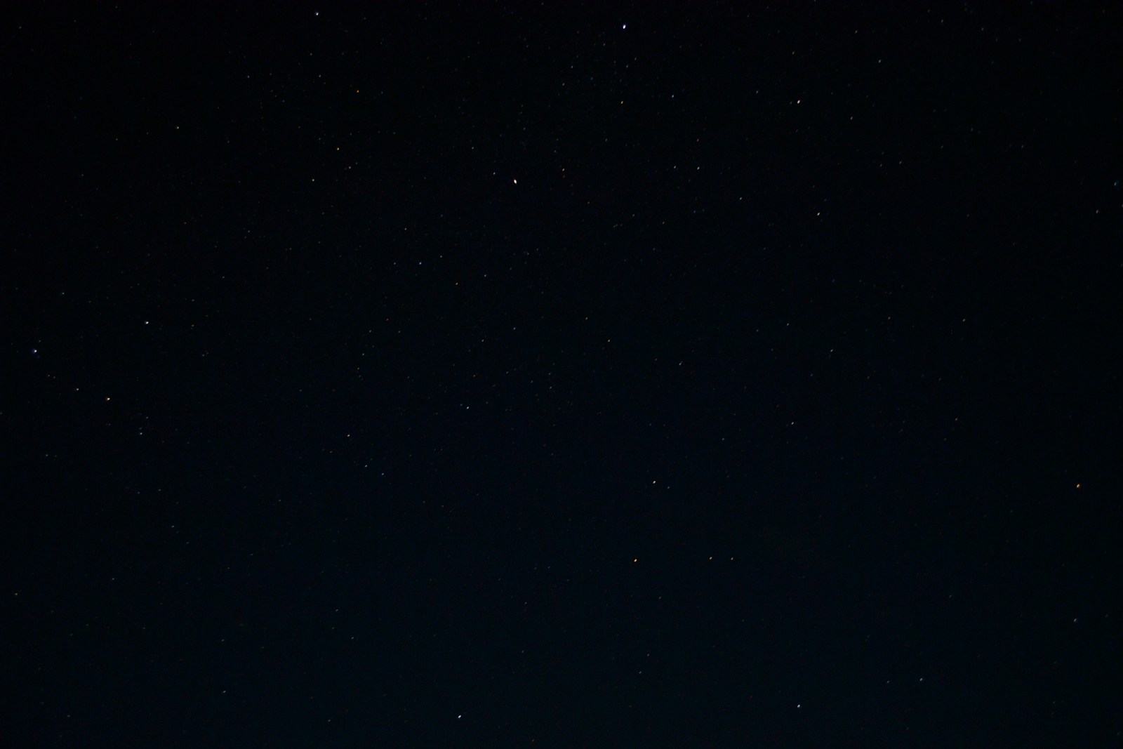 a night sky with stars and a few clouds